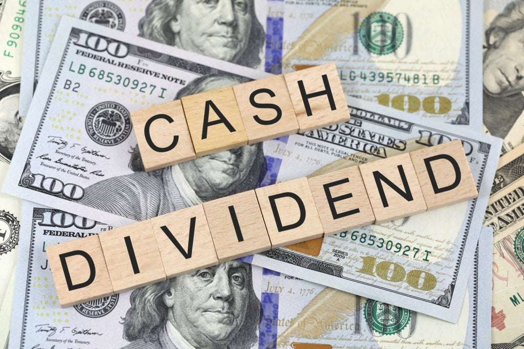 dollars met een bordje met de tekst 'contant dividend'